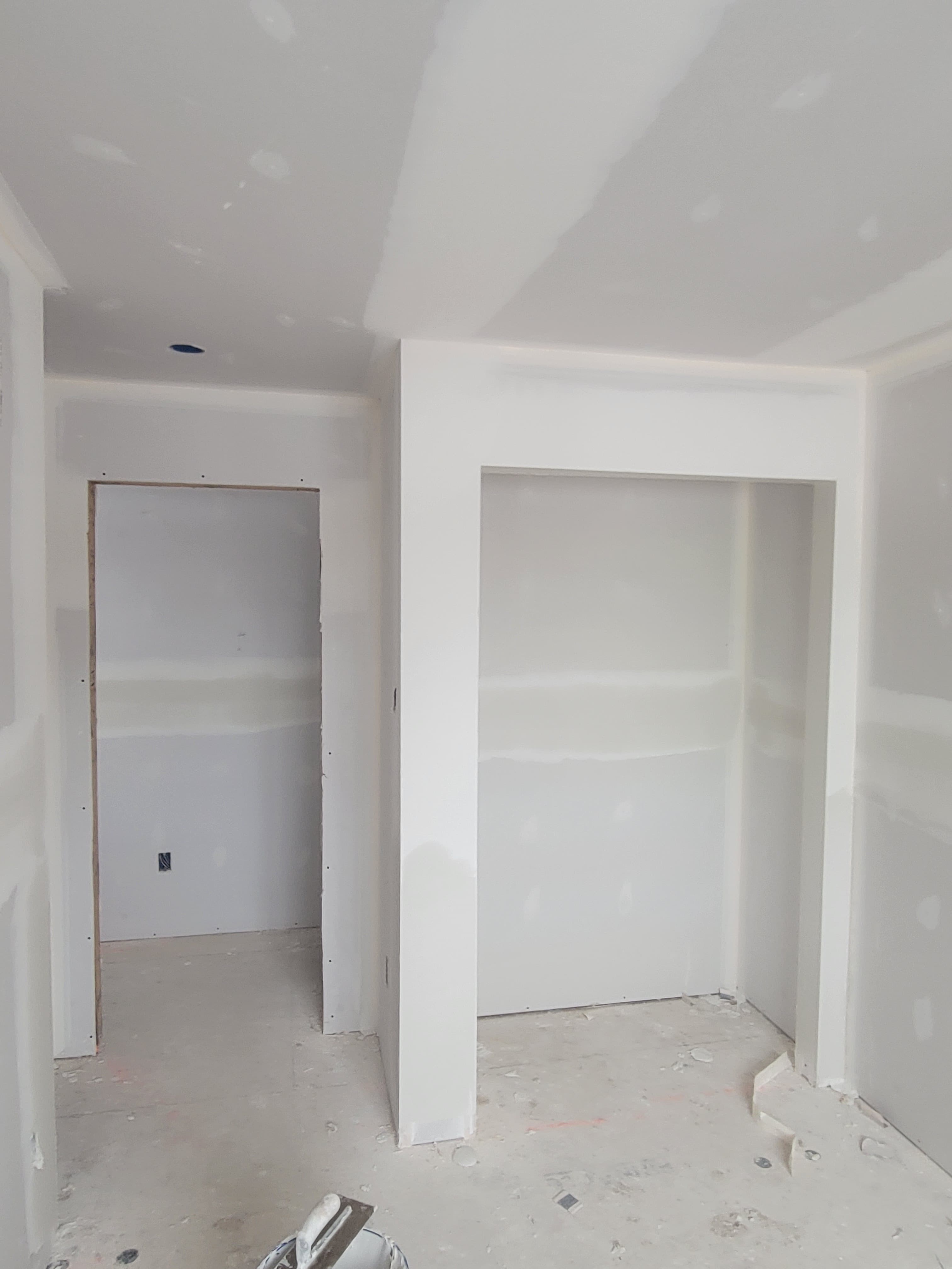 Unfinished interior room with white drywall walls and two large rectangular recessed wall niches.
